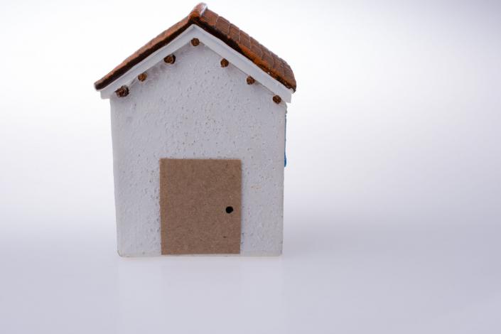 Small white model house on a white gradient background