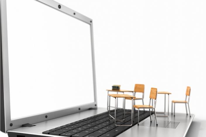 open laptop with small wooden table and chairs on the keyboard